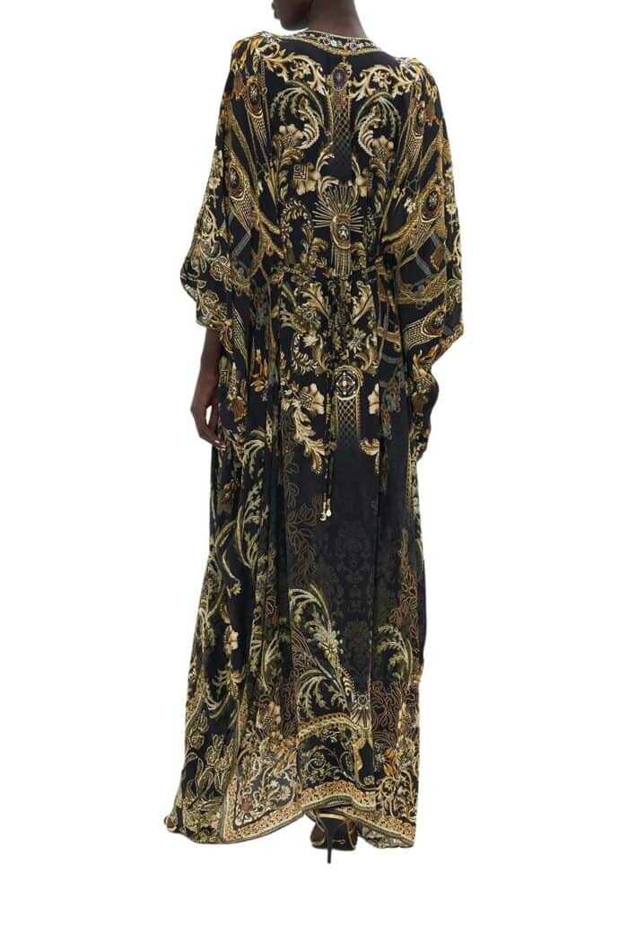 Back view of long silk kaftan on model from Camilla in black based print with gold highlights and hardware.