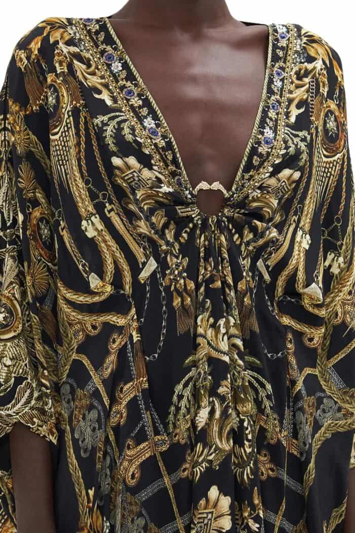 Front top detail view of long silk kaftan on model from Camilla in black based print with gold highlights and hardware.
